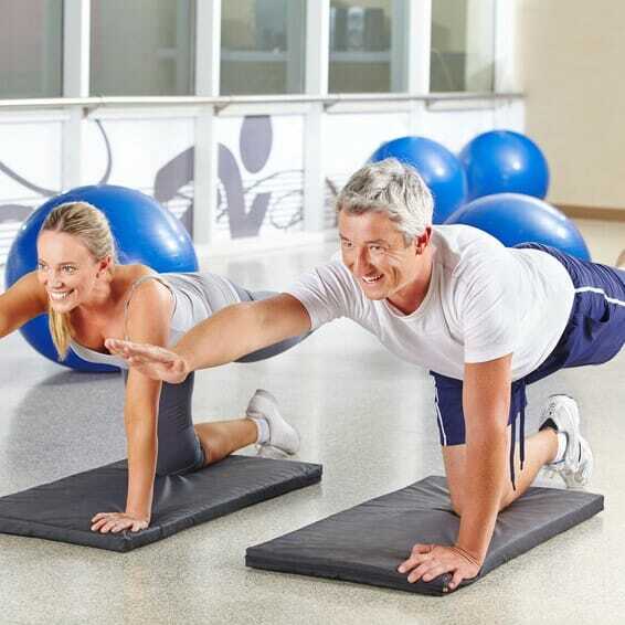 Mann und Frau machen Gymnastik im Fitnesscenter